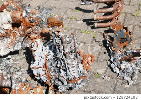 A pile of rusted metal parts and a burnt engine A pile of rusted metal parts and a burnt engine 128724198