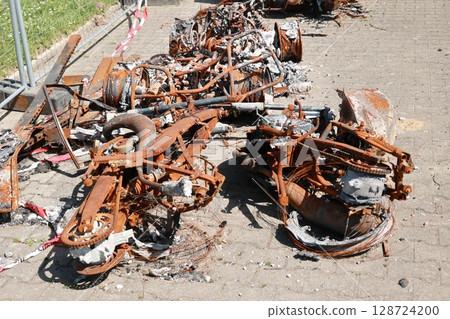 A pile of rusted and burnt metal parts on the ground A pile of rusted and burnt metal parts on the ground 128724200