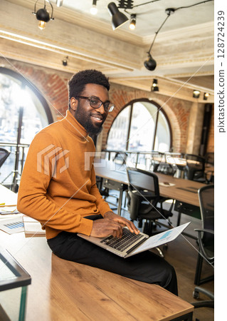 African american young man with laptop working in the office 128724239