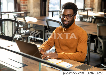 African american young man with laptop working in the office 128724255
