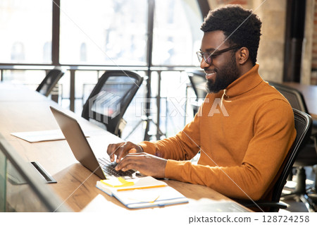 African american young man with laptop working in the office 128724258