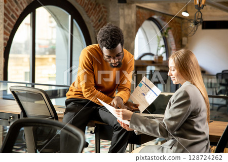 Colleagues working together in the office and looking contented 128724262