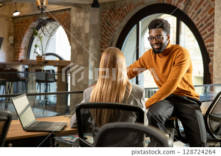 Colleagues working together in the office and looking contented 128724264