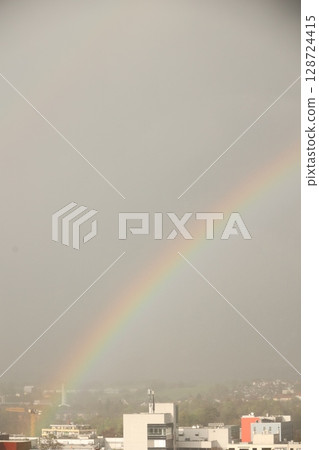 A rainbow is seen in the sky above a city A rainbow is seen in the sky above a city 128724415