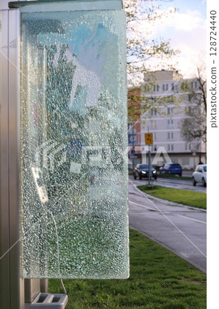 A broken glass window on a bus stop A broken glass window on a bus stop 128724440