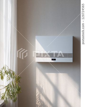 Modern white wall-mounted air ventilation unit in natural light. Clean interior mockup for smart tech, energy systems, or climate control visuals Modern white wall-mounted air ventilation unit in natural light. Clean interior mockup for smart tech, energy systems, or climate control visuals 128724565