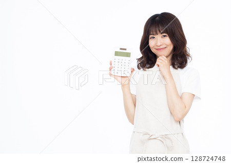 一位家庭主婦拿著計算器，微笑著思考 128724748