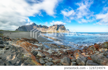 Amazing sunny day and dramatic black sand beach on Stokksnes cape in Iceland 128724974