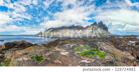 Amazing sunny day and dramatic black sand beach on Stokksnes cape in Iceland Amazing sunny day and dramatic black sand beach on Stokksnes cape in Iceland 128724981