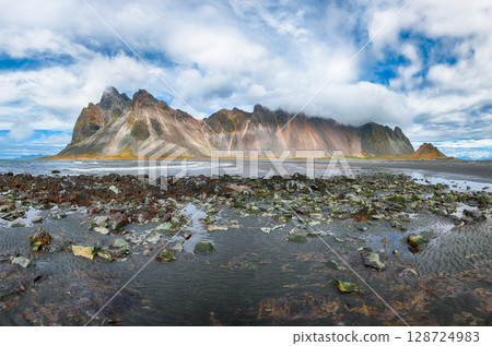 Amazing sunny day and dramatic black sand beach on Stokksnes cape in Iceland Amazing sunny day and dramatic black sand beach on Stokksnes cape in Iceland 128724983