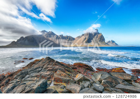 Amazing sunny day and dramatic black sand beach on Stokksnes cape in Iceland 128724986