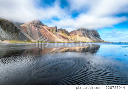 Amazing  sunny day and gorgeous reflection of Vestrahorn mountaine on Stokksnes cape in Iceland. 128725044