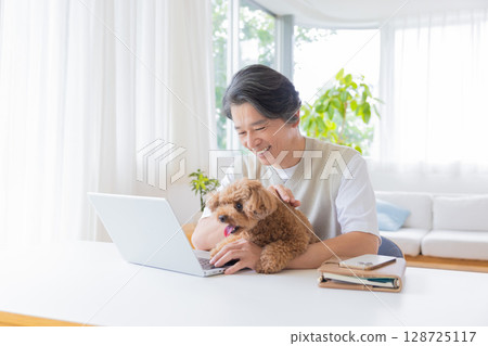 Telework: A man working while holding a dog 128725117