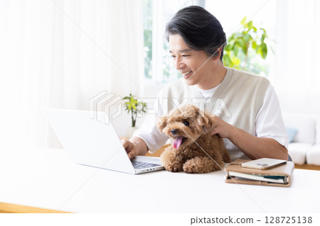 Telework: A man working while holding a dog 128725138