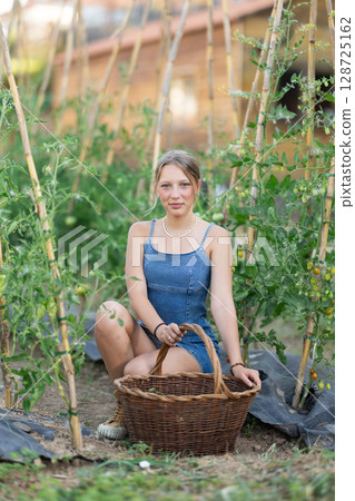 Young woman with basket in cottage garden Young woman with basket in cottage garden 128725162