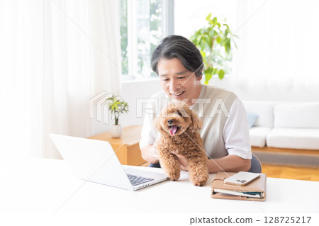 Telework: A man working while holding a dog 128725217