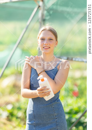 Female rural worker uses sunscreen 128725351