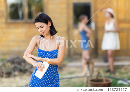 Female rural worker uses sunscreen 128725357