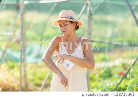 Female rural worker uses sunscreen Female rural worker uses sunscreen 128725361