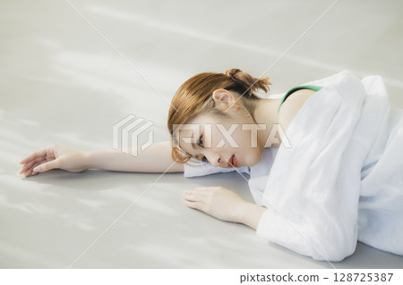 A woman lying on the floor 128725387