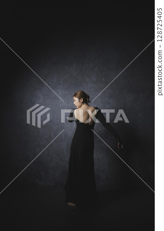 黑色背景下擺姿勢的女人 黑色背景下擺姿勢的女人 128725405