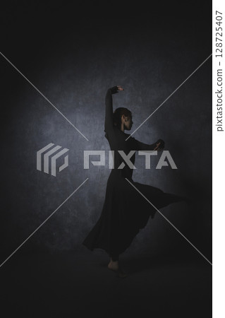 黑色背景下擺姿勢的女人 黑色背景下擺姿勢的女人 128725407