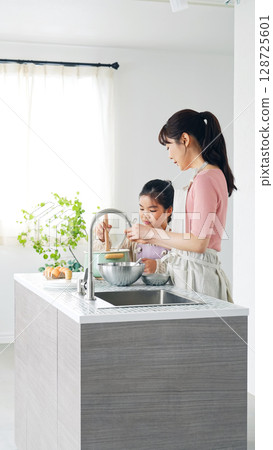 Parent and child cooking in the kitchen Parent and child cooking in the kitchen 128725601