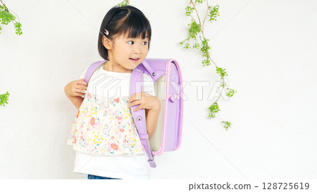 Girls carrying a school bag Girls carrying a school bag 128725619