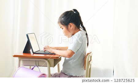 Girl using laptop in classroom Girl using laptop in classroom 128725625
