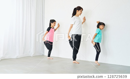 Parents and children exercising in the room 128725639