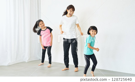 Parents and children exercising in the room 128725640