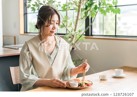Restaurant, young asian woman eating in dining room 128726107