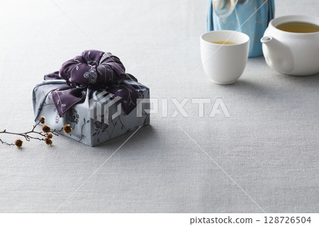 Elegant Korean table setting with traditional Korean bojagi gift wrapping for Chuseok, ceramic vase and fabric, tree branches. Elegant Korean table setting with traditional Korean bojagi gift wrapping for Chuseok, ceramic vase and fabric, tree branches. 128726504