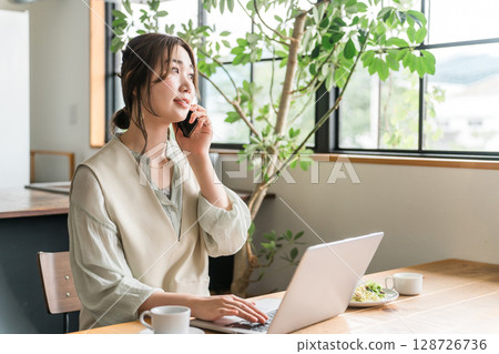 在咖啡館遠距辦公/工作的亞洲年輕女性 在咖啡館遠距辦公/工作的亞洲年輕女性 128726736