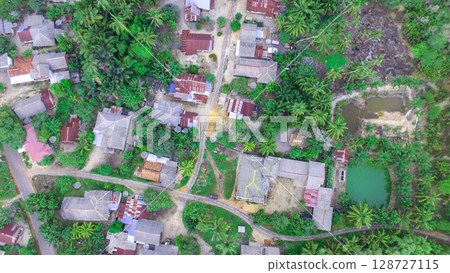 Aerial View of Rural Tropical Village with Traditional Houses and Lush Greenery Aerial View of Rural Tropical Village with Traditional Houses and Lush Greenery 128727115