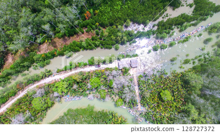 Aerial View of Riverside Dock with Wooden Boats in Tropical Mangrove Area 128727372