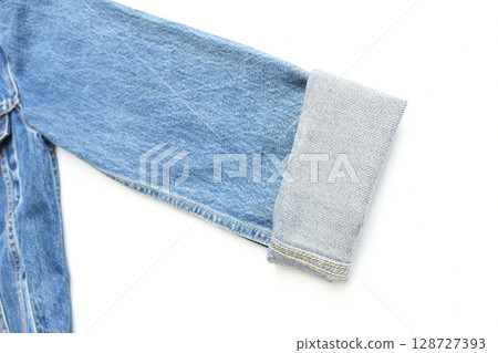 roll up sleeve of blue denim shirt texture isolated on white background, jean fashion style 128727393