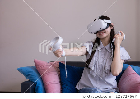 A Japanese woman enjoying virtual reality with VR goggles in the living room at home 128727667