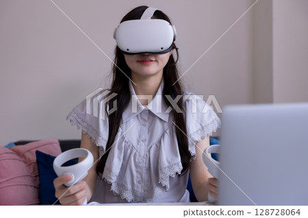 A Japanese woman enjoying virtual reality with VR goggles in the living room at home 128728064