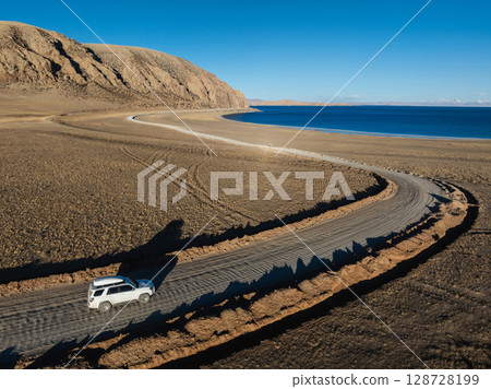 Aerial view of  offroad car running on corrugated road in the remote part of Tibet, China 128728199