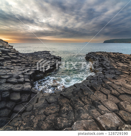 Landscape with black volcanic basalt columns on rocky beach by the sea. Da Da reef or Ganh Da Dia in Phu Yen province in Vietnam at sunrise 128729190