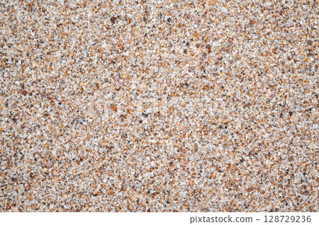 sandy texture of sand on beach by sea close up. Background with a natural sandy pattern in coast 128729236