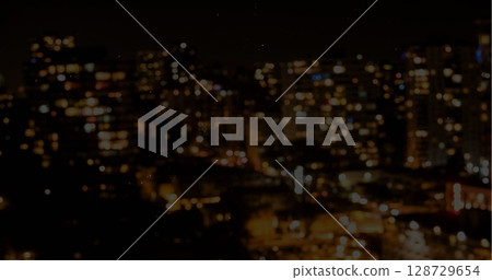 Displaying blurred city lights forming bokeh over nighttime urban skyline, warm and cool tones 128729654