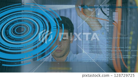 Inspecting Asian man checking patch cables in data center, with digital code overlay and blue HUD 128729725