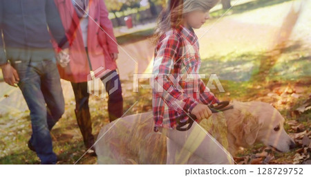 Walking girl leading golden retriever on leash in leafy park path with fallen leaves, copy space Walking girl leading golden retriever on leash in leafy park path with fallen leaves, copy space 128729752