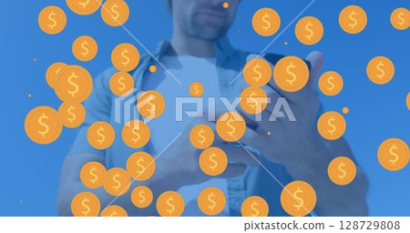 Casually dressed mid adult man holding smartphone in studio, with animated gold coins overlay 128729808