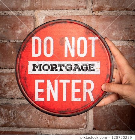 Red Do Not Enter Mortgage Sign Held by Hand Against Brick Wall Background for Financial Concept Red Do Not Enter Mortgage Sign Held by Hand Against Brick Wall Background for Financial Concept 128730259