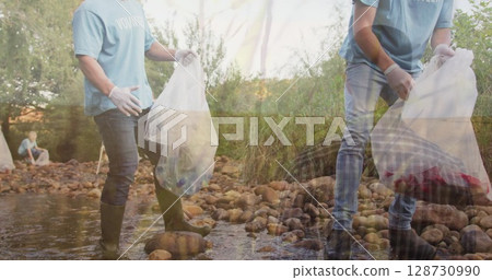 Image of grass over two caucasian men collecting rubbish in forest Image of grass over two caucasian men collecting rubbish in forest 128730990