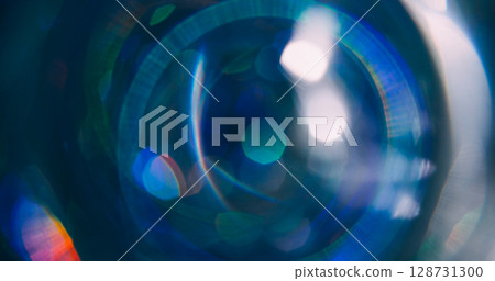 Light circle. Bokeh ray. Defocused green blue colorful sparkling optical round lens flare moving on abstract dark black background. Light circle. Bokeh ray. Defocused green blue colorful sparkling optical round lens flare moving on abstract dark black background. 128731300