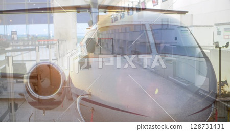 Displaying private jet nose over airport gate area, with business casual woman rolling suitcase Displaying private jet nose over airport gate area, with business casual woman rolling suitcase 128731431